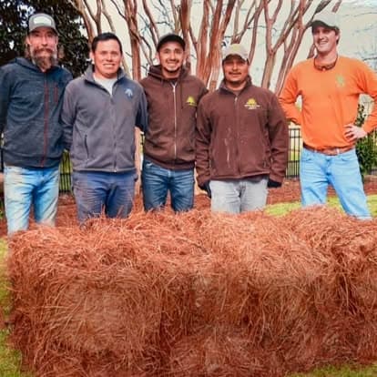 Richard Smith and the Smith Straw crew of five behind freshly raked pine straw bales