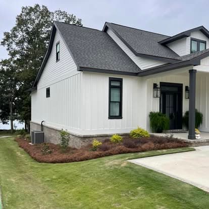 White modern Fairhope farmhouse with fresh pine straw foundation beds