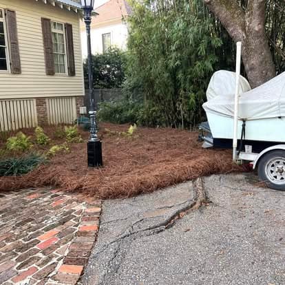Lamppost with fresh pine straw bed and brick edging on a downtown street